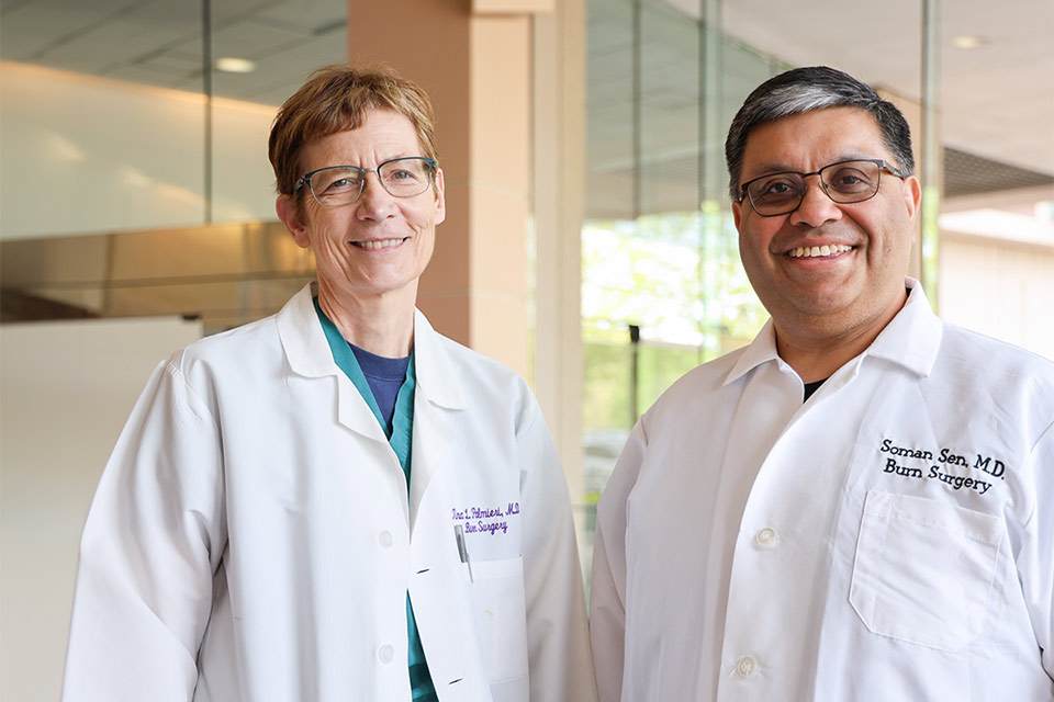 Male and female physicians standing and smiling