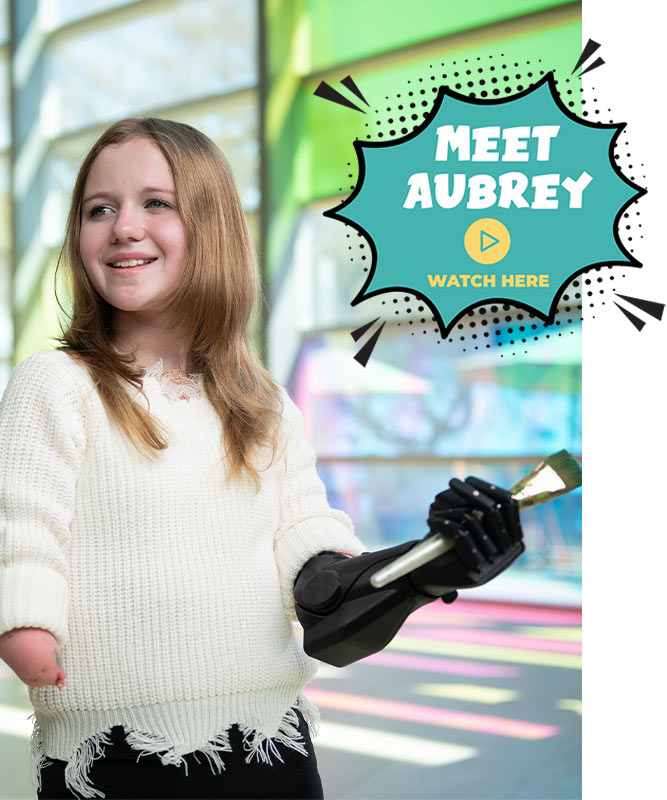 Patient with prosthetic arm holding paintbrush; Meet Aubrey; Watch Video