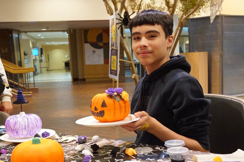 boy holding pumpkin during halloween party