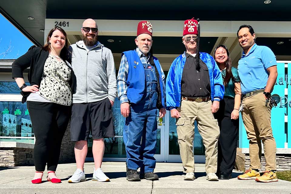 Deux Al Kader Shriners locaux avec deux membres du personnel de l’Hôpital Shriners pour enfants de Portland.