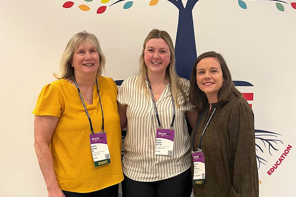 Three staff members attending conference and smiling