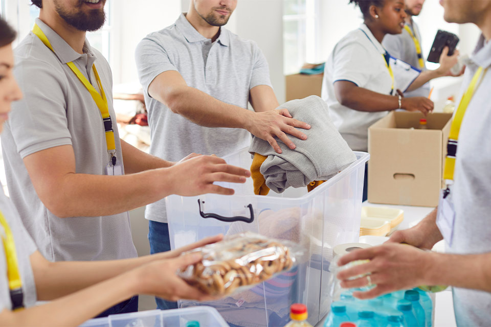 Voluntarios colocando donaciones en cajas transparentes.