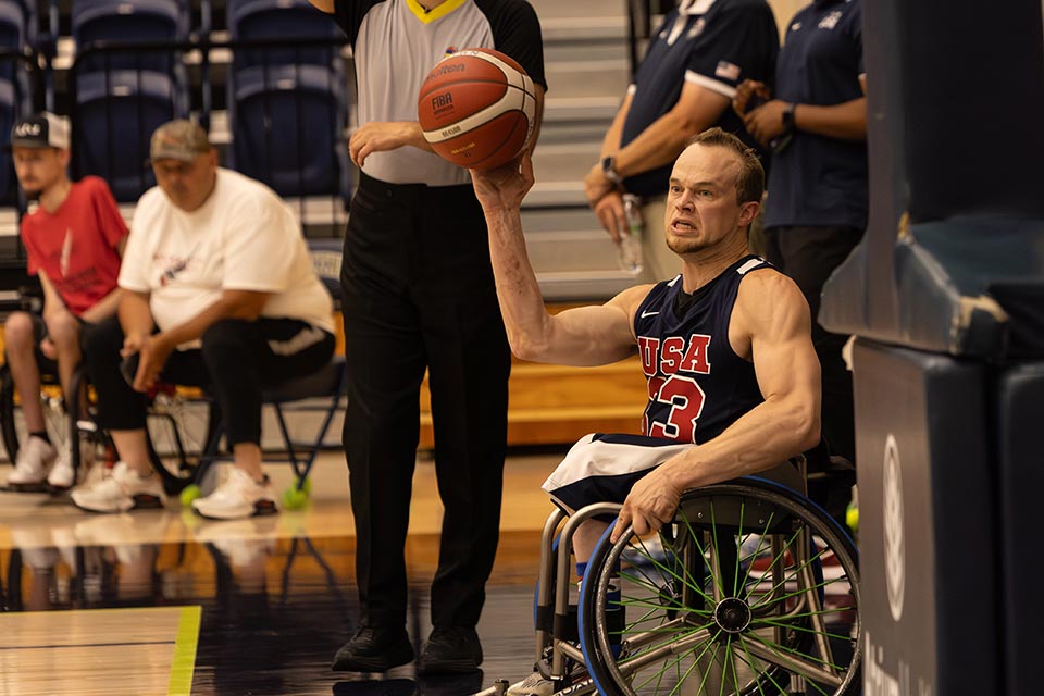 John participe à un match de basket-ball en fauteuil roulant