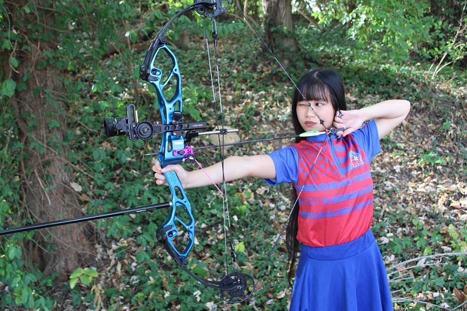 Kiera con arco y flecha, alineada para tirar