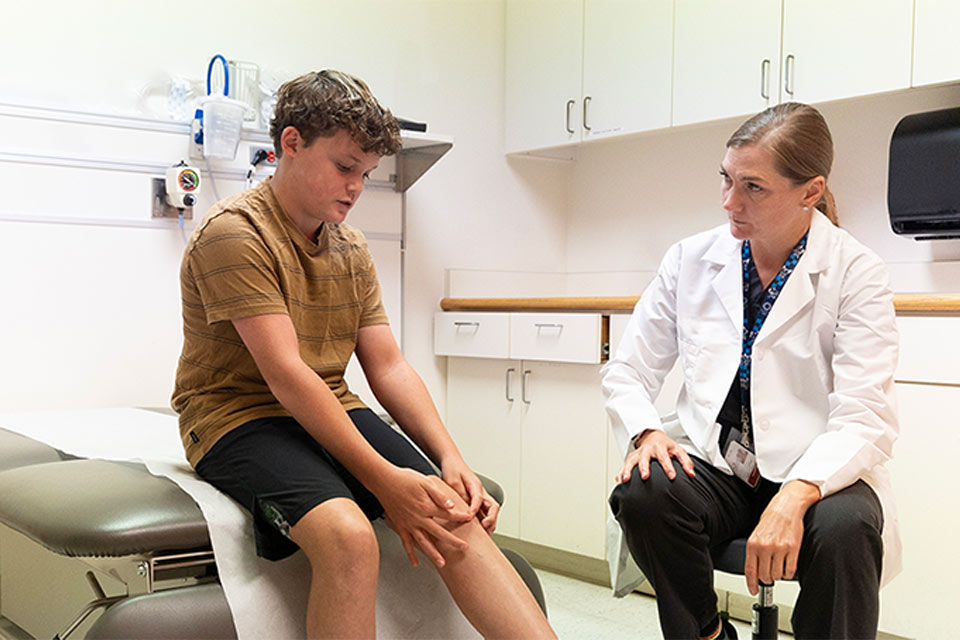 Physician speaking with patient in exam room