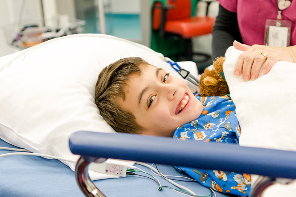 Un niño sonriendo en una cama quirúrgica del hospital