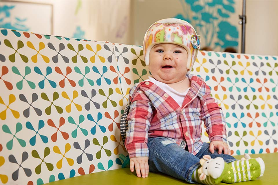 Paciente con casco sonriendo en el asiento