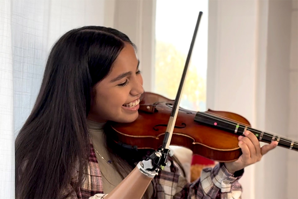 Patient jouant du violon avec une prothèse de bras